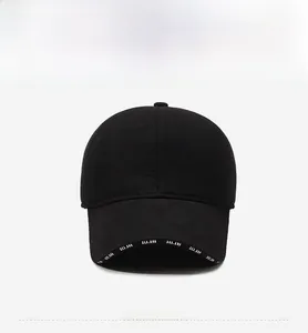 Detail of black winter baseball cap featuring fashion metal plate and letter printed brim