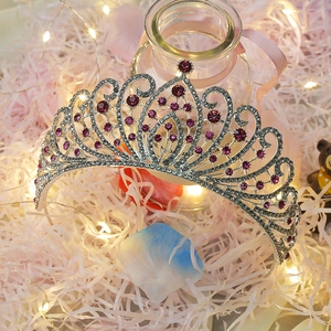 Macro detail of silver tiara showing purple gemstones and sparkling rhinestone patterns