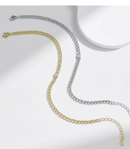 Detail of gold and silver cuban link bracelets with round moissanite and lobster clasp