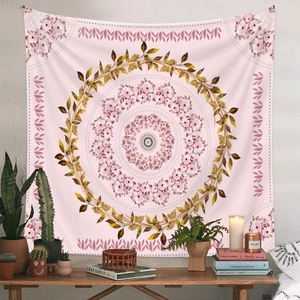 Pink mandala tapestry with golden floral wreath in a cozy bohemian room setting
