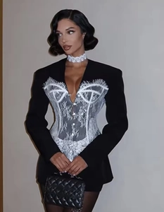 Détail de robe blazer noire avec empiècement en dentelle blanche et col en V ajusté