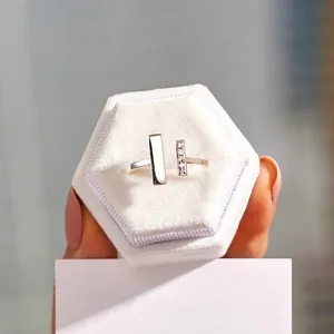 Minimalist silver geometric open ring with cubic zirconia inlay on a jewelry box