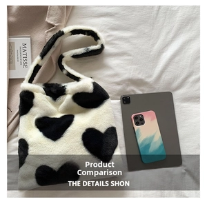 Detail of plush heart tote bag with soft faux fur texture and large black heart pattern