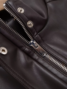 Détail de la fermeture éclair en métal argenté et bouton pression sur veste marron