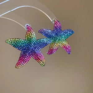 Macro shot of silver needle starfish earrings featuring colorful rainbow zircon pavé crystals