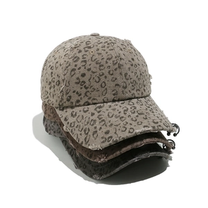 Distressed leopard print baseball cap with metal rings in multiple colors on white background