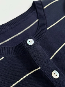 Detailed view of striped knit cardigan collar with elegant pearl-like buttons