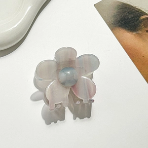 Detailansicht einer perlmuttfarbenen Blumen-Haarklammer aus Acetat mit blauem Mittelstein