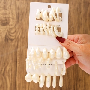 Detail of cream white pearl resin earring set with teardrop and geometric hoop shapes
