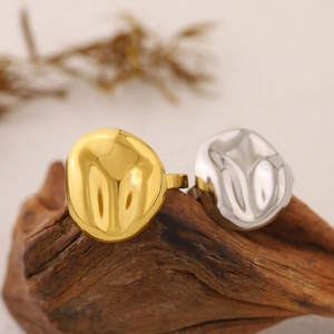 Unregelmäßige 18K Gold und Silber beschichtete Kieselringe auf einer Naturholzbasis