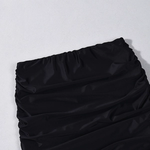 Detailed macro view of the ruched fabric and gathered stitching on this black long sleeve top