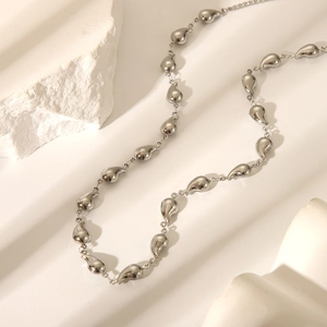 Detailed close-up of water-drop shape silver titanium steel chain link necklace