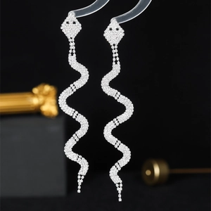 Sparkling long tassel snake-shaped earrings with full rhinestone inlay on a black background