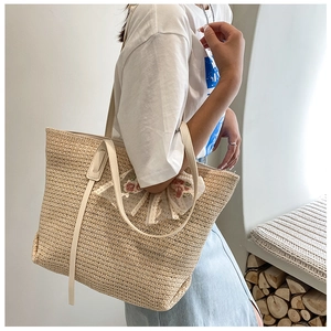 Detail of summer straw tote bag with elegant lace floral charms and slim shoulder straps