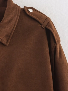 Detail der Schulterpartie einer dunkelbraunen Wildlederjacke mit silbernem Metallknopf