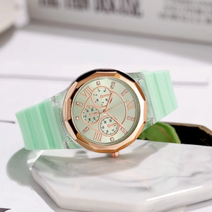 Detail of mint green silicone strap and rose gold metal case with diamond hour markers