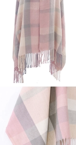 Detailed view of pink and grey checkered winter scarf with soft tassel fringe finish