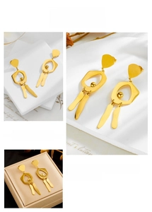 Detail view of gold geometric earrings with pentagon frame and long metal tassel pendants