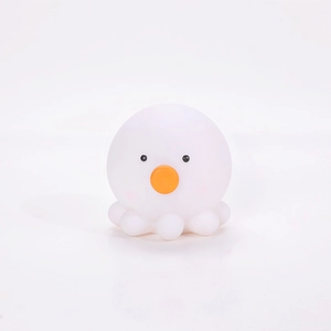 Close-up of a white octopus silicone night light with an orange nose and soft texture