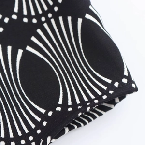 Detailed macro shot showing black fabric with white geometric patterns and stitching