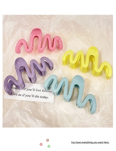 Detail showing wave-shaped hair clips in pink, purple, yellow, and blue glossy finishes