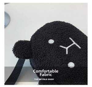Close-up of soft black plush sherpa fabric with embroidered animal face details