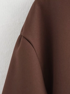 Detailed close-up of brown woven fabric and shoulder stitching on a vintage skirt suit