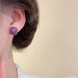 Close-up of elegant purple square resin stud earring worn on ear with glossy candy finish