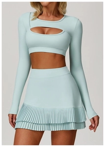 Détail du crop top à manches longues bleu clair avec découpe ajourée et jupe de sport plissée