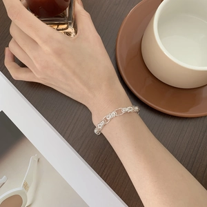 Detail of S925 sterling silver handmade woven bracelet on wrist with elegant lifestyle decor