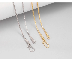 Macro detail of gold and silver dragon bone chain necklaces with secure hook clasps
