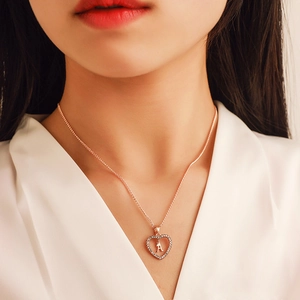 Rose gold heart necklace with rhinestones and letter A pendant on a female model