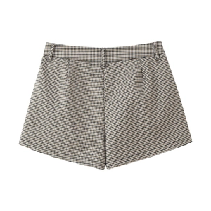 Flat lay of plaid pattern shorts in brown and black tones with retro tweed texture