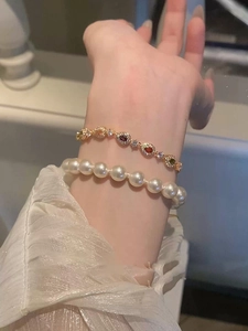 Macro view of French chic bracelets featuring colorful teardrop gems and white pearls