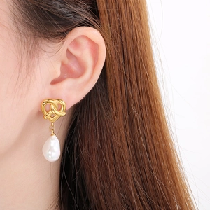 Vintage heart knot stainless steel drop earrings with white baroque pearls on model