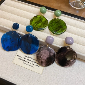 Detailed close-up of retro irregular resin earrings in green, blue, and purple tones