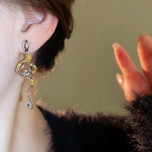 Silver snake-shaped dangle earring with yellow accents and a clear water-drop crystal