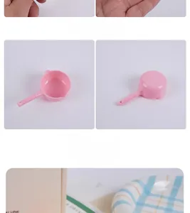 Close-up of pink miniature plastic water scoop with handle for dollhouse kitchen decor