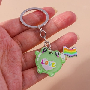 Cute green frog keychain holding a rainbow flag with LOVE heart detail for daily bags
