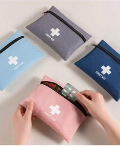 Close-up of putting medicine capsules into a portable first aid kit bag in pink