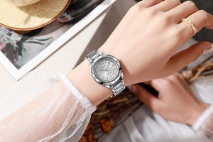Gros plan d'une élégante montre à quartz argentée avec lunette lettrée au poignet