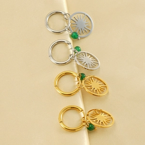 Detail of sun charm hoop earrings with green beads in gold and silver plating