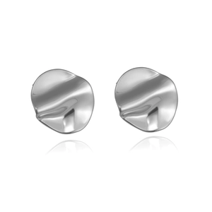 Macro view of silver irregular wavy round stud earrings with high-polish metallic finish
