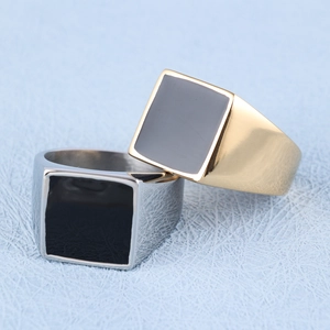 Detail of square signet rings in gold and silver finish with black enamel inlay