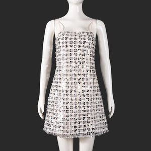 Détail des paillettes argentées sur une robe de soirée courte à fines bretelles