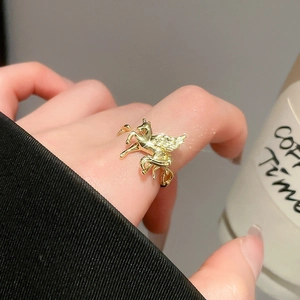 Detail of golden winged horse ring with sparkling zircons worn on index finger