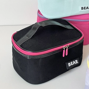 Close-up of mesh makeup bag with dual zippers and bear logo detailing