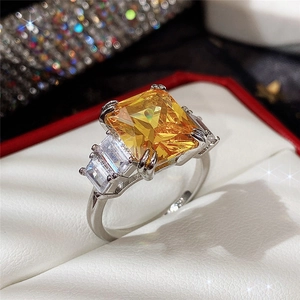 Macro shot of square yellow zircon ring with four-prong setting and side accents