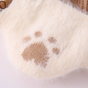 Close-up of soft beige knit fabric with brown cat paw pattern and fluffy plush texture