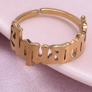 Macro shot of gold Aquarius zodiac cutout lettering on adjustable stainless steel ring